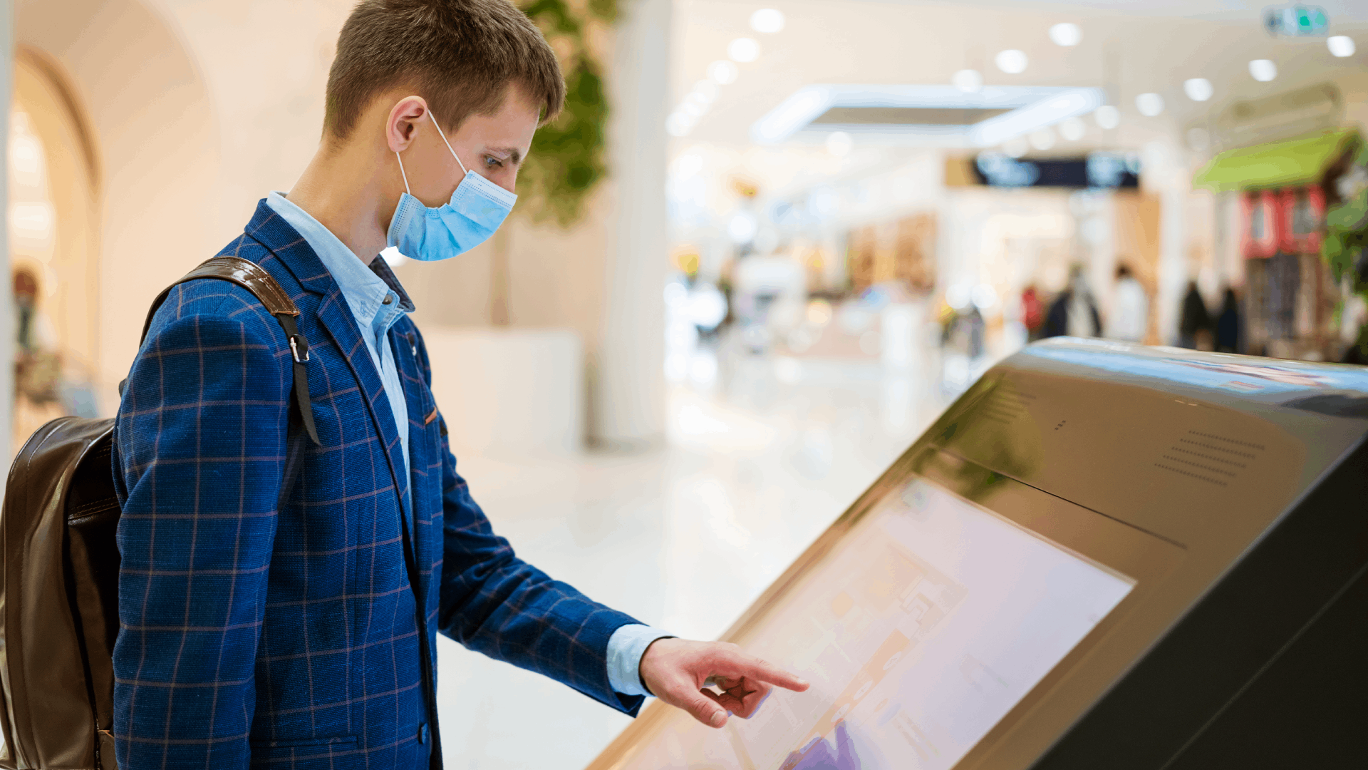 young-man-in-the-mall-looks-at-the-monitor-in-a-ma-2023-11-27-05-10-13-utc